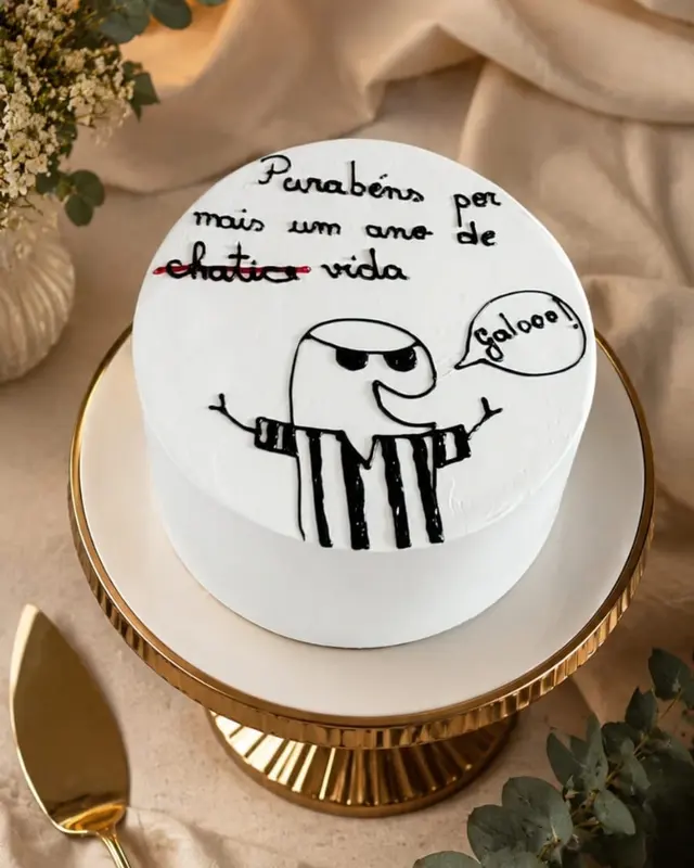 Bolo branco liso com desenho e recado escritos à mão no topo